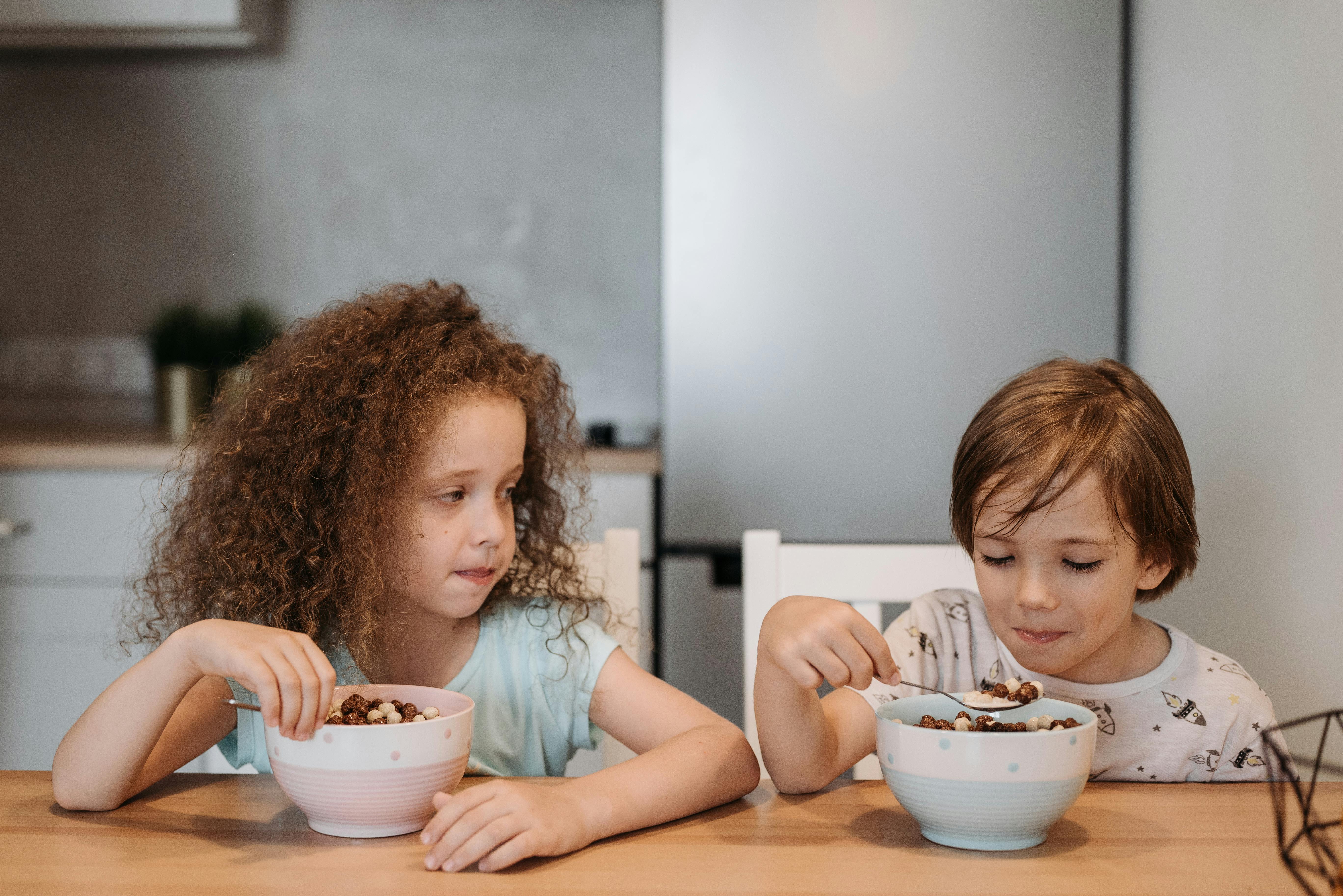 Primary school children eating breakfast together during free breakfast schools programme
